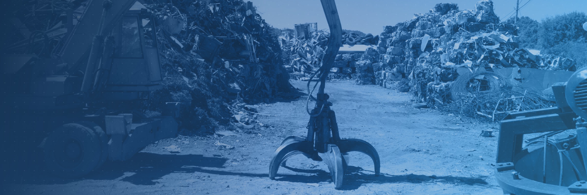 Scrap yard with a grapple loader and sorted metal piles