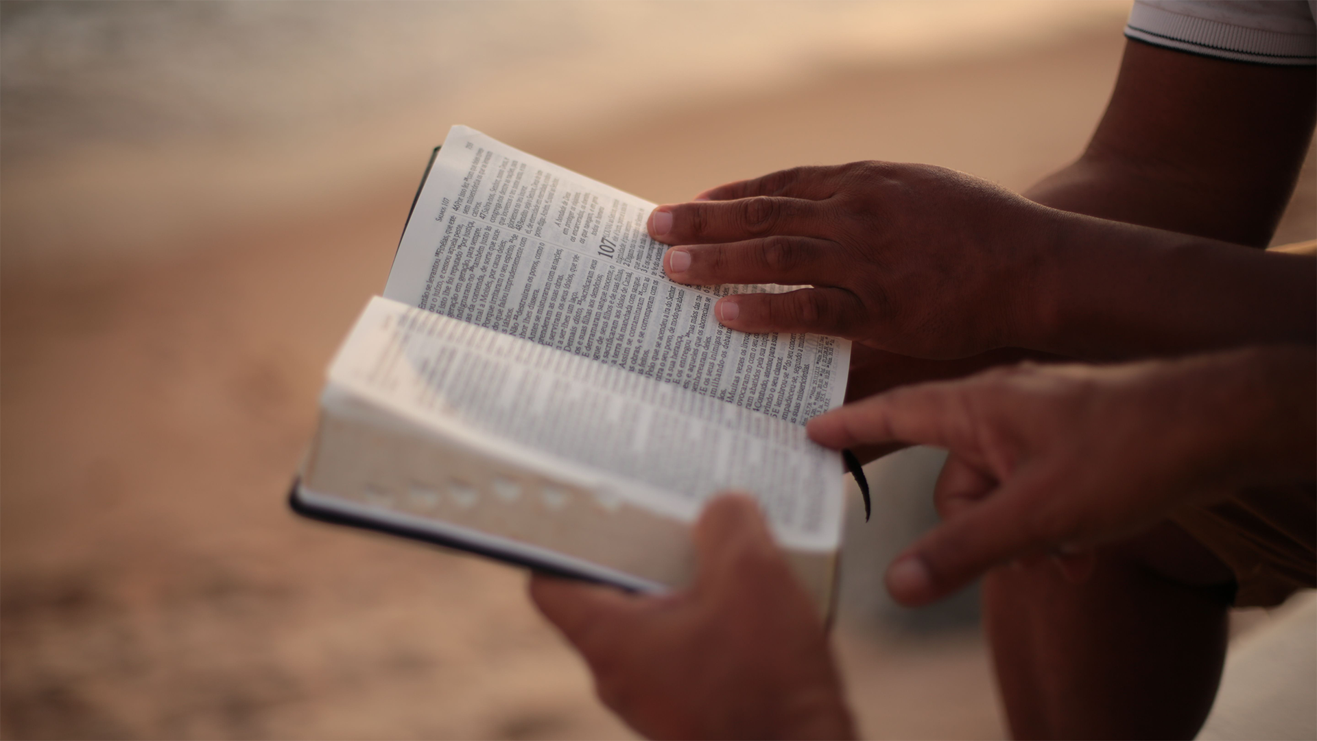Hands holding an open Bible
