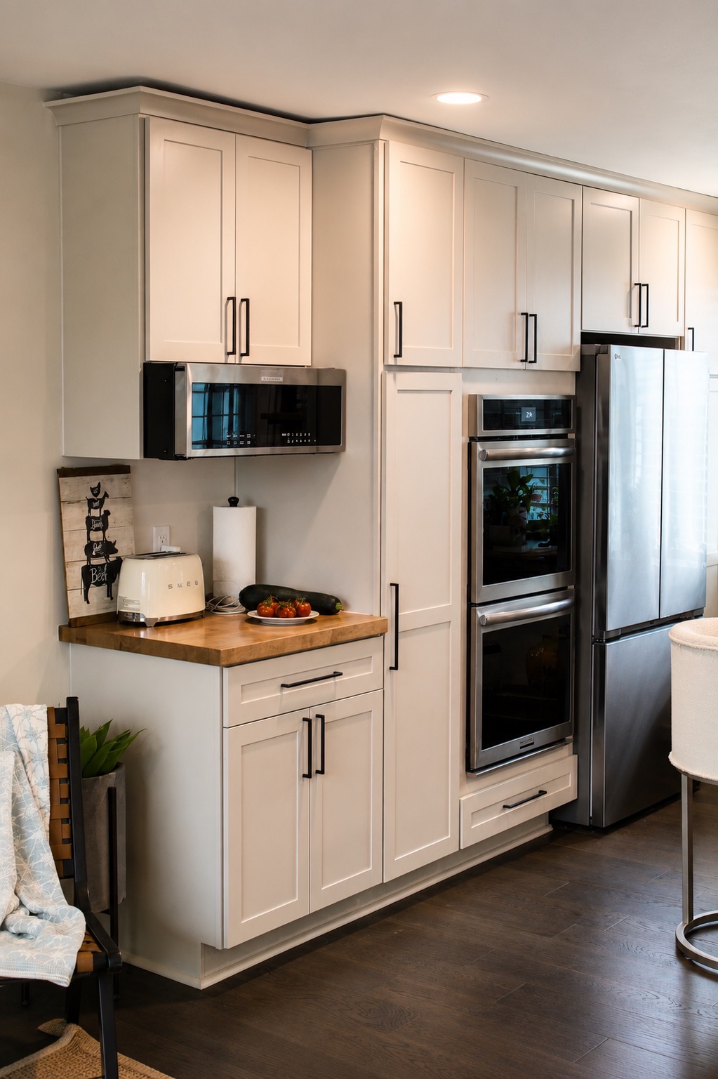 White kitchen cabinets with butcher block counter and double wall oven