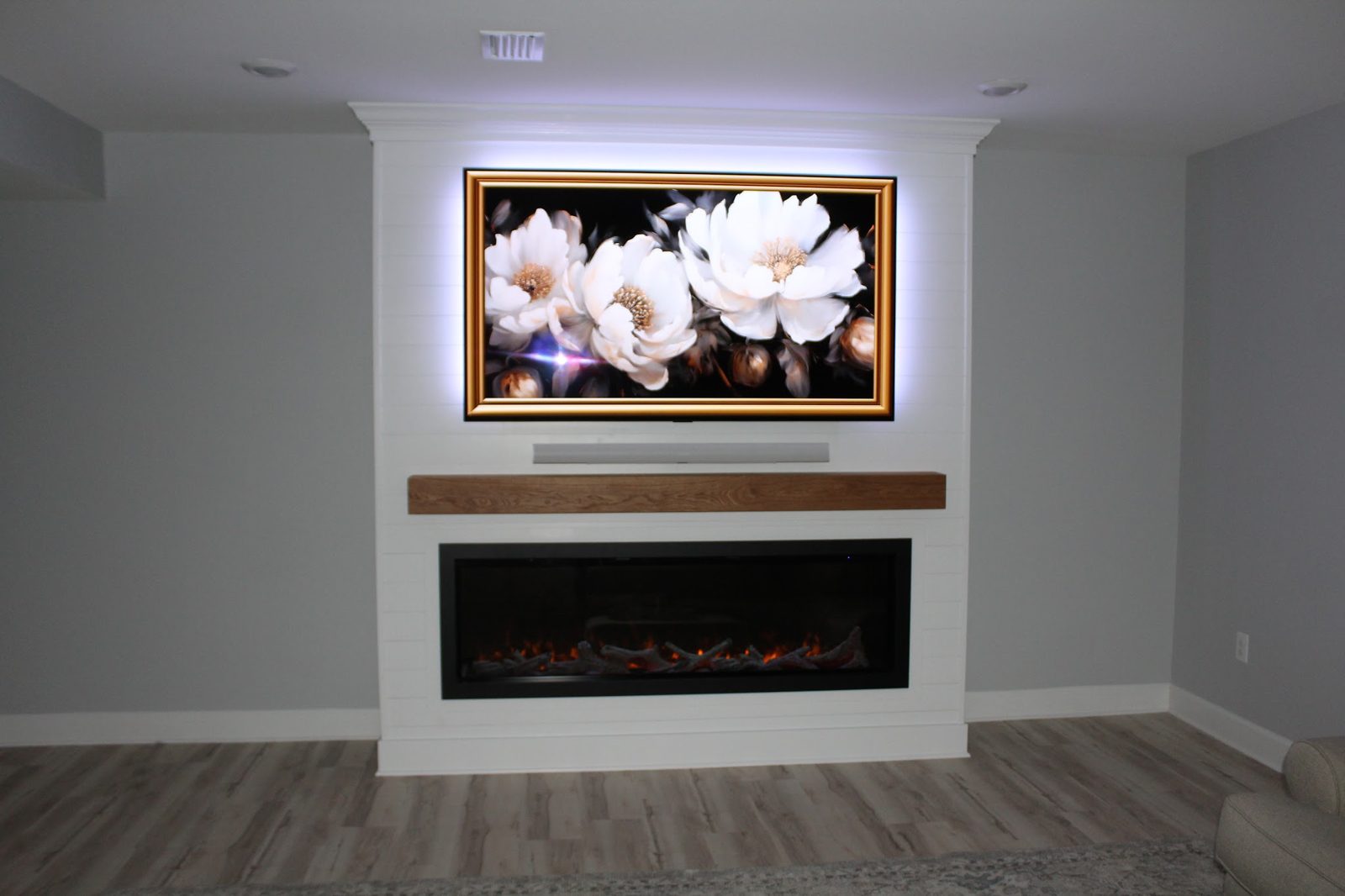 Custom shiplap entertainment center with electric fireplace and white oak mantel