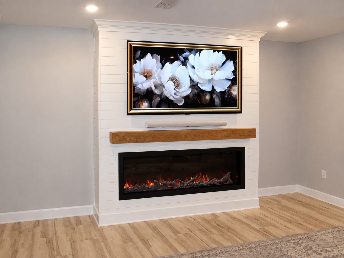 Custom shiplap built-in with electric fireplace and white oak mantel