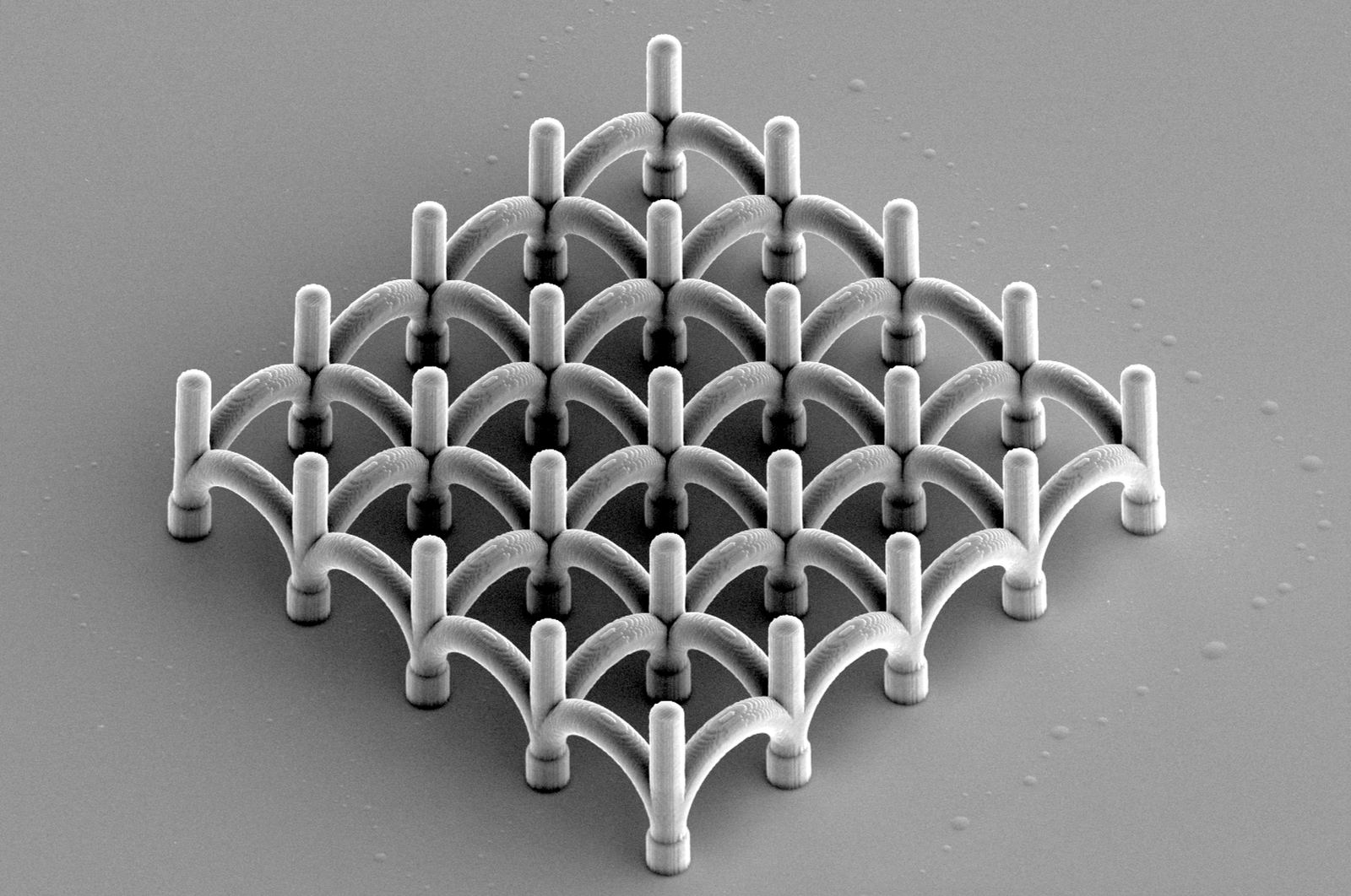 Scanning electron micrograph of a network of U-bends, arched links written between rows of vertical pillars.