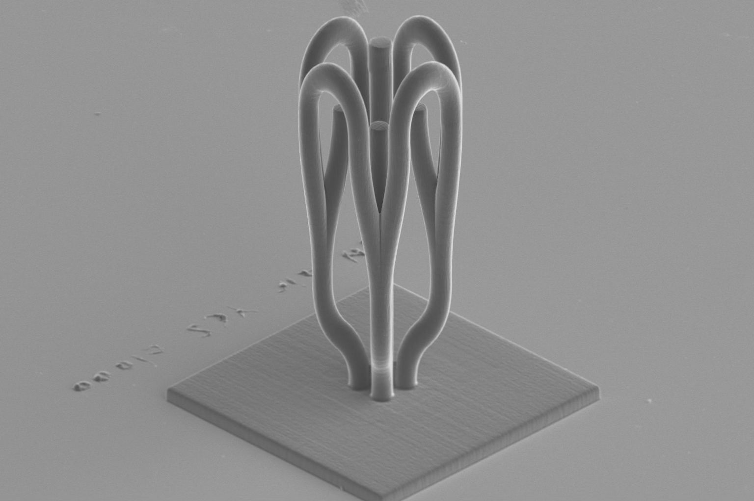 Scanning electron micrograph of a 3D routing structure splitting one input into two curved outputs.
