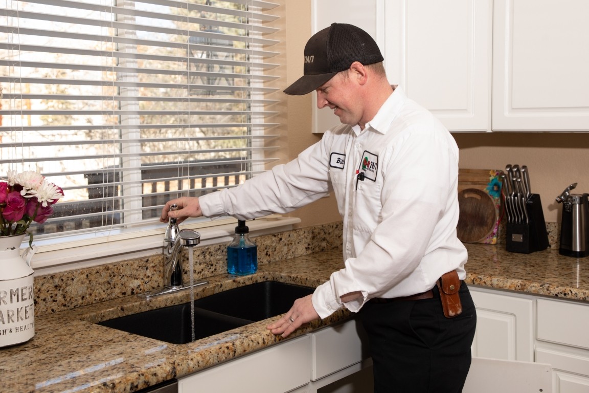 Plumber unclogging kitchen sink