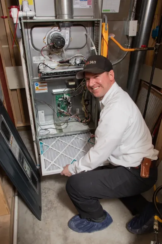 A technician pulling out an air filter.