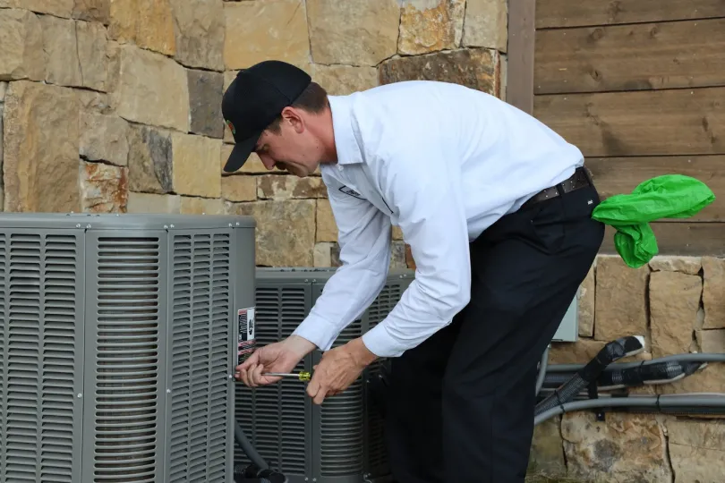 A technician working on finishing up an AC install.