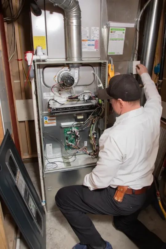 A technician looking over a furnace install.