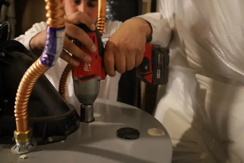 A technician working on a water heater.