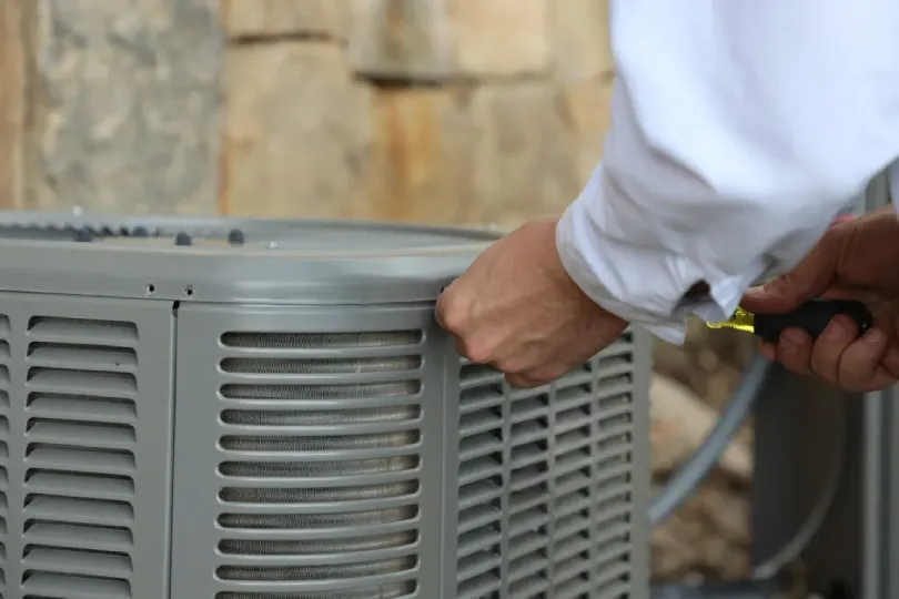 A technician outside working on an AC unit.