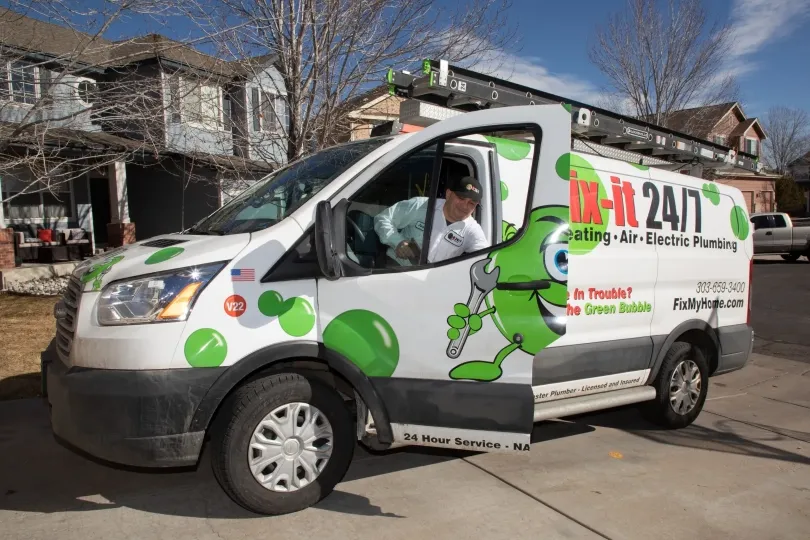 A technician getting out of a Fix-it truck, he has arrived at a customer's house.