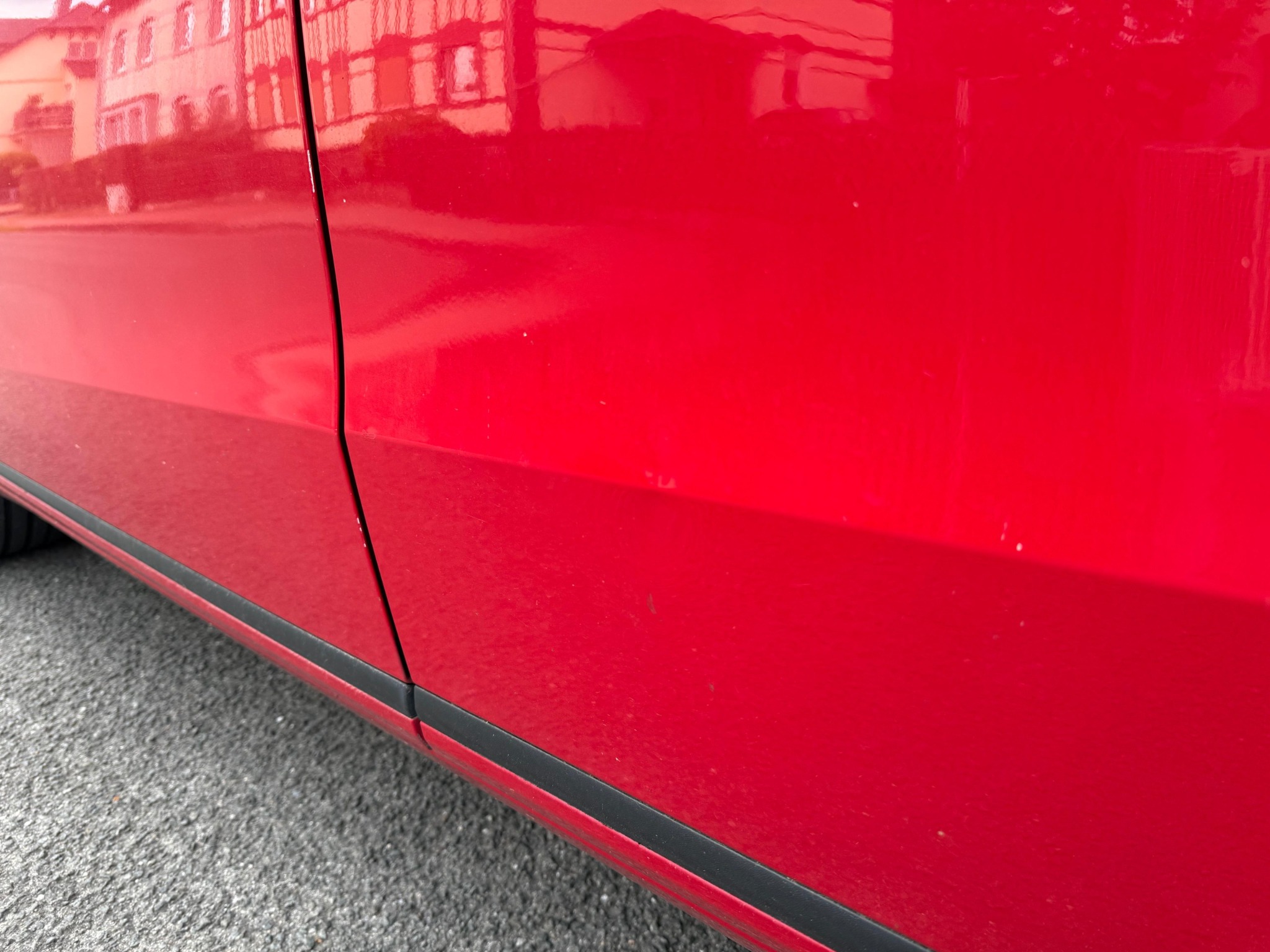 Detailaufnahme einer roten Fahrzeugtür.