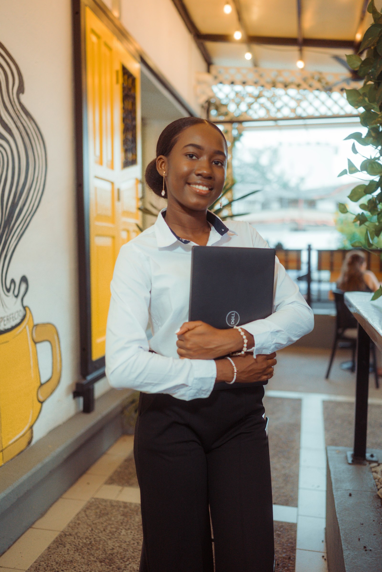 Business owner holding a laptop in a cafe