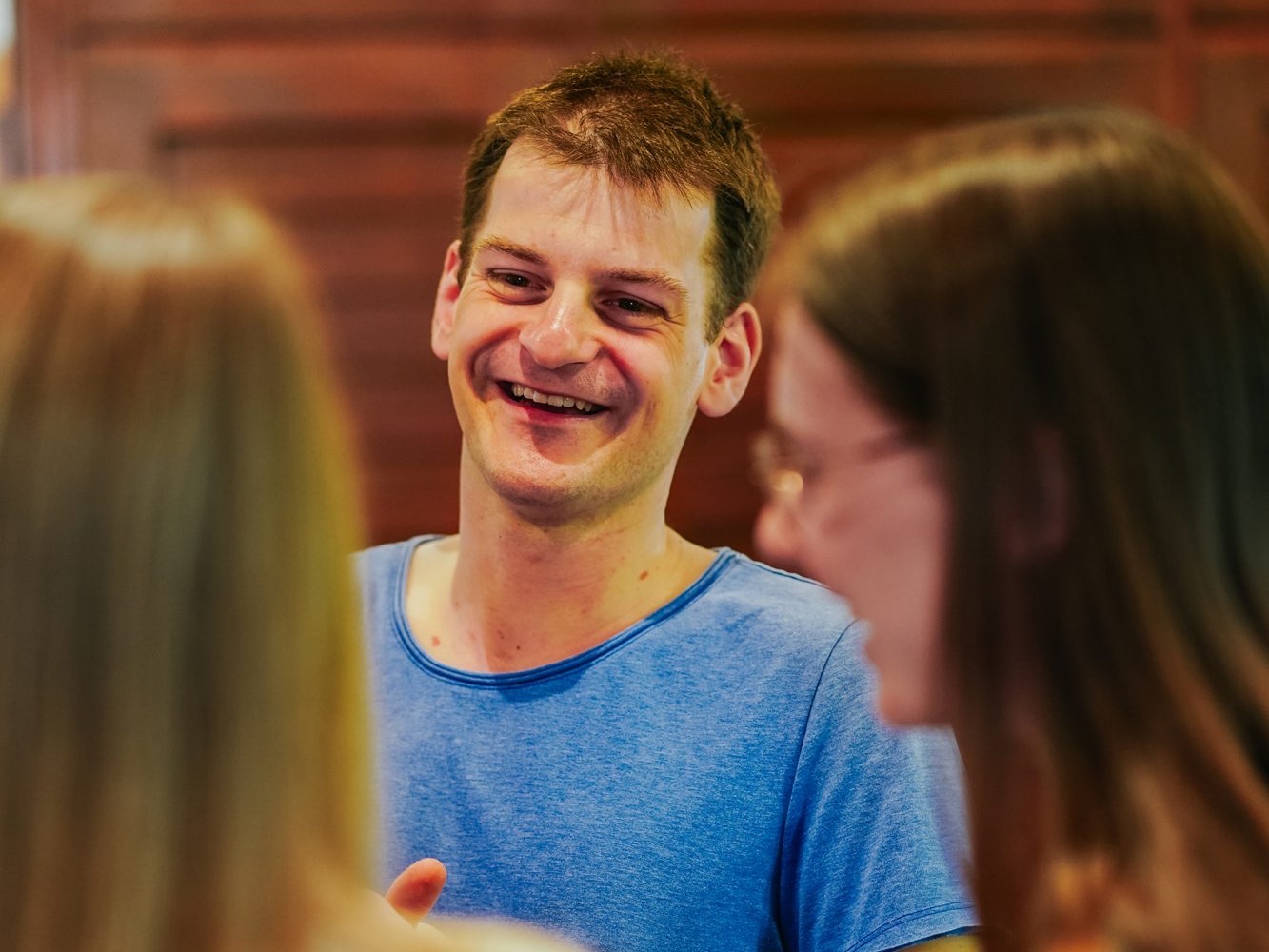 Junge Menschen sitzen lachend zusammen am Tisch