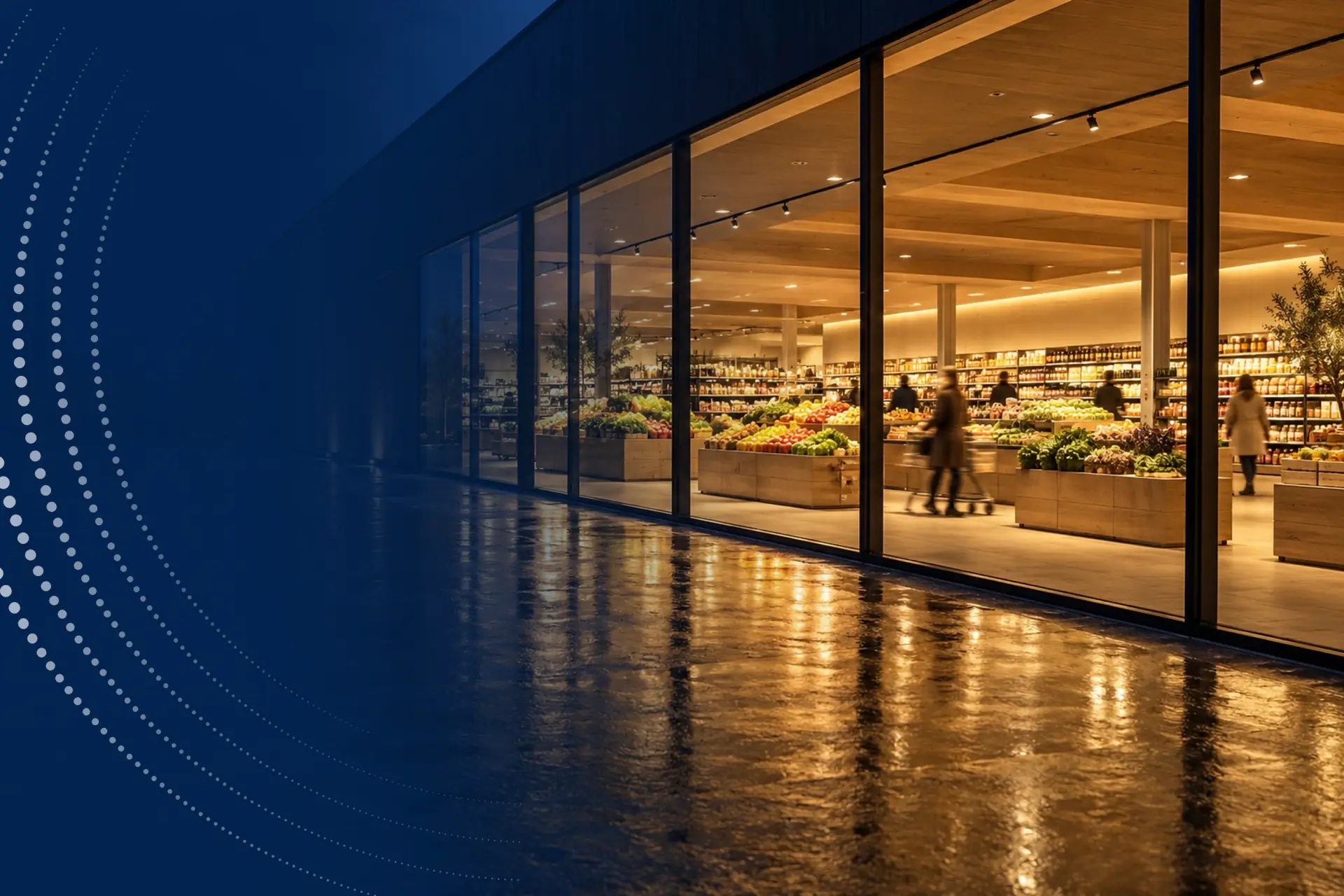 A brightly lit food store at night, seen through its glass façade.