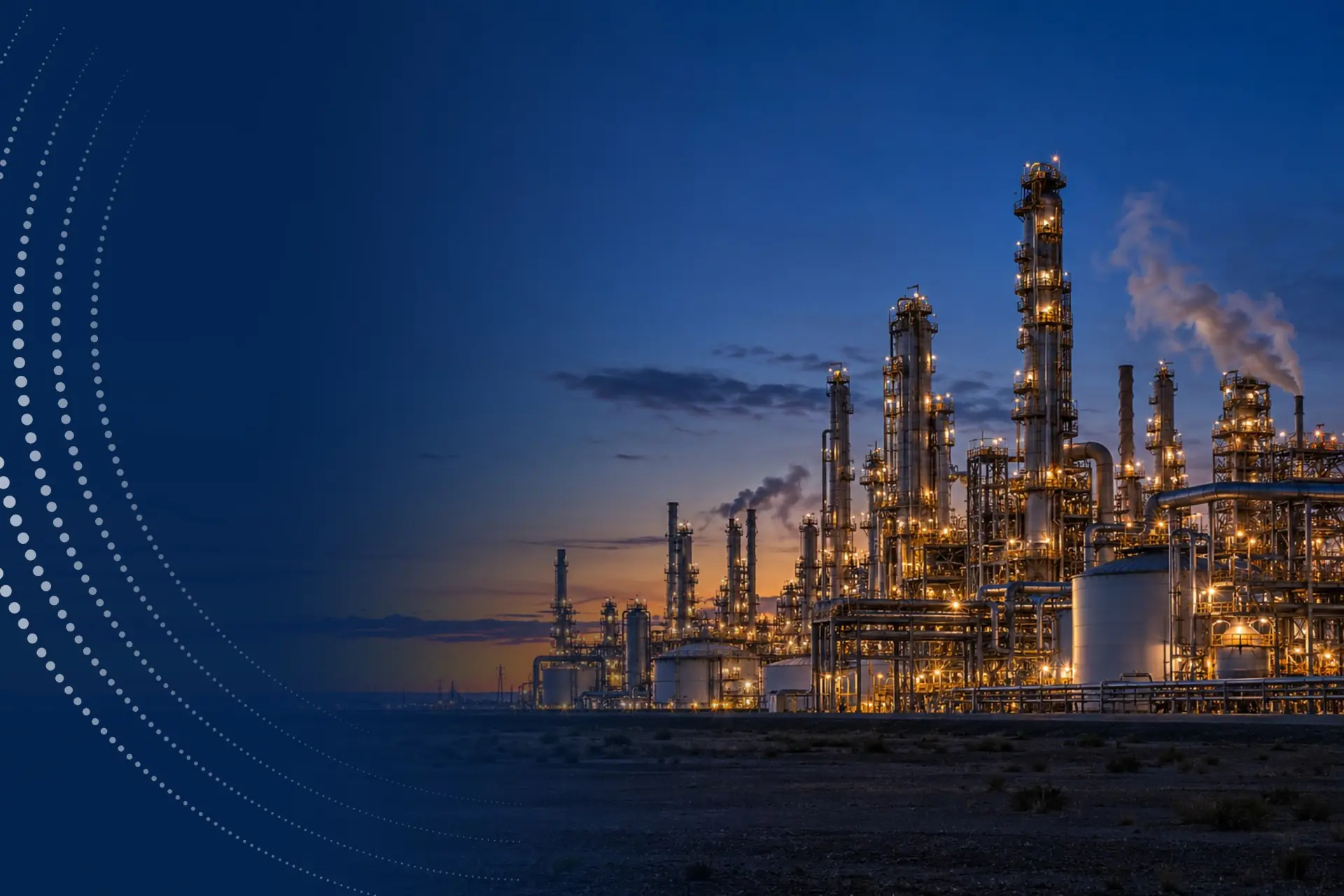 A chemical plant with illuminated process columns at dusk.