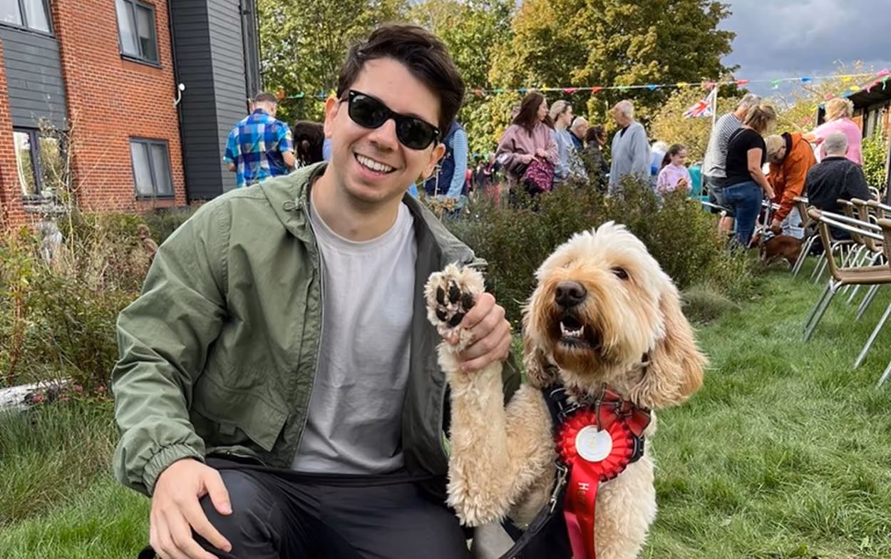 Image of Phil next to a Goldendoodle