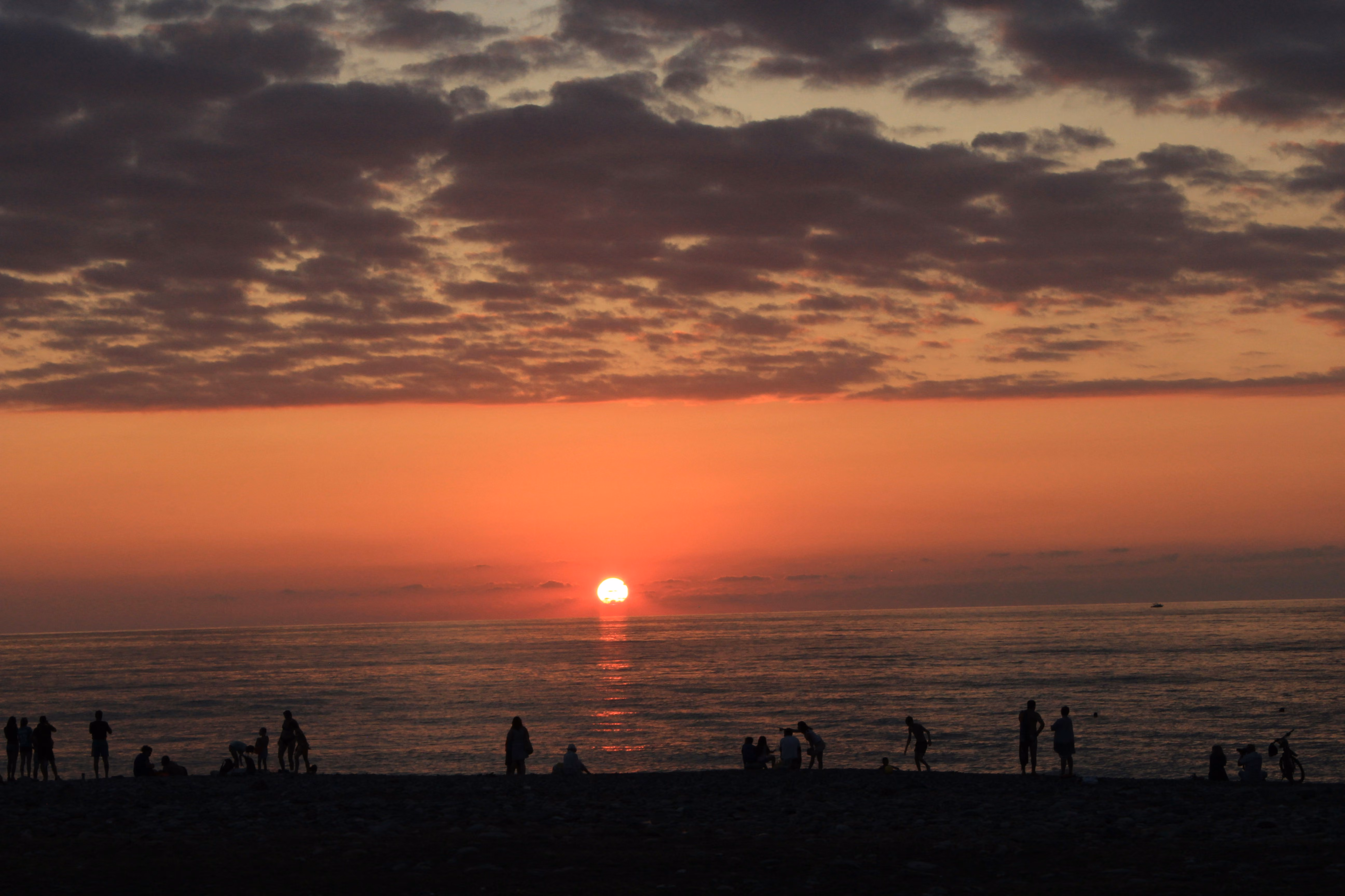 Silhouettes of people on the beach at sunset