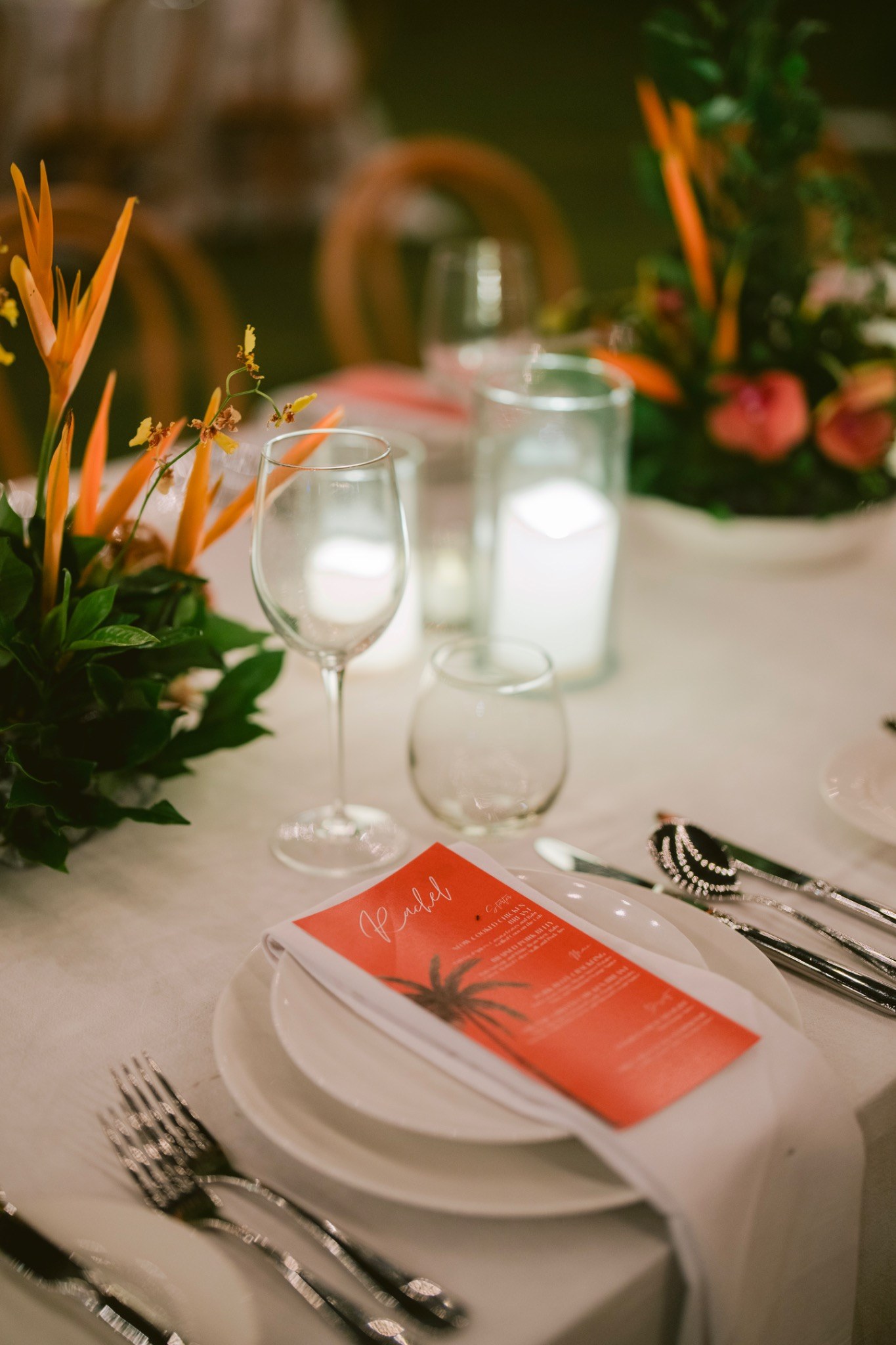 Table setting with tropical flowers, candles and a menu card at a wedding reception