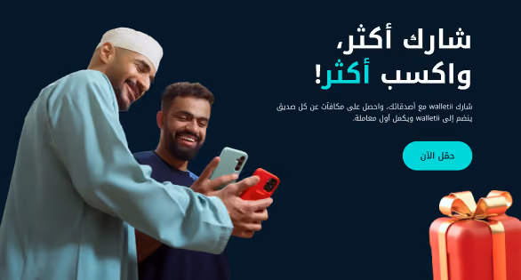 صديقان ينظران إلى هاتفيهما بجانب صندوق هدية أحمر، لعرض شارك أكثر واكسب أكثر.