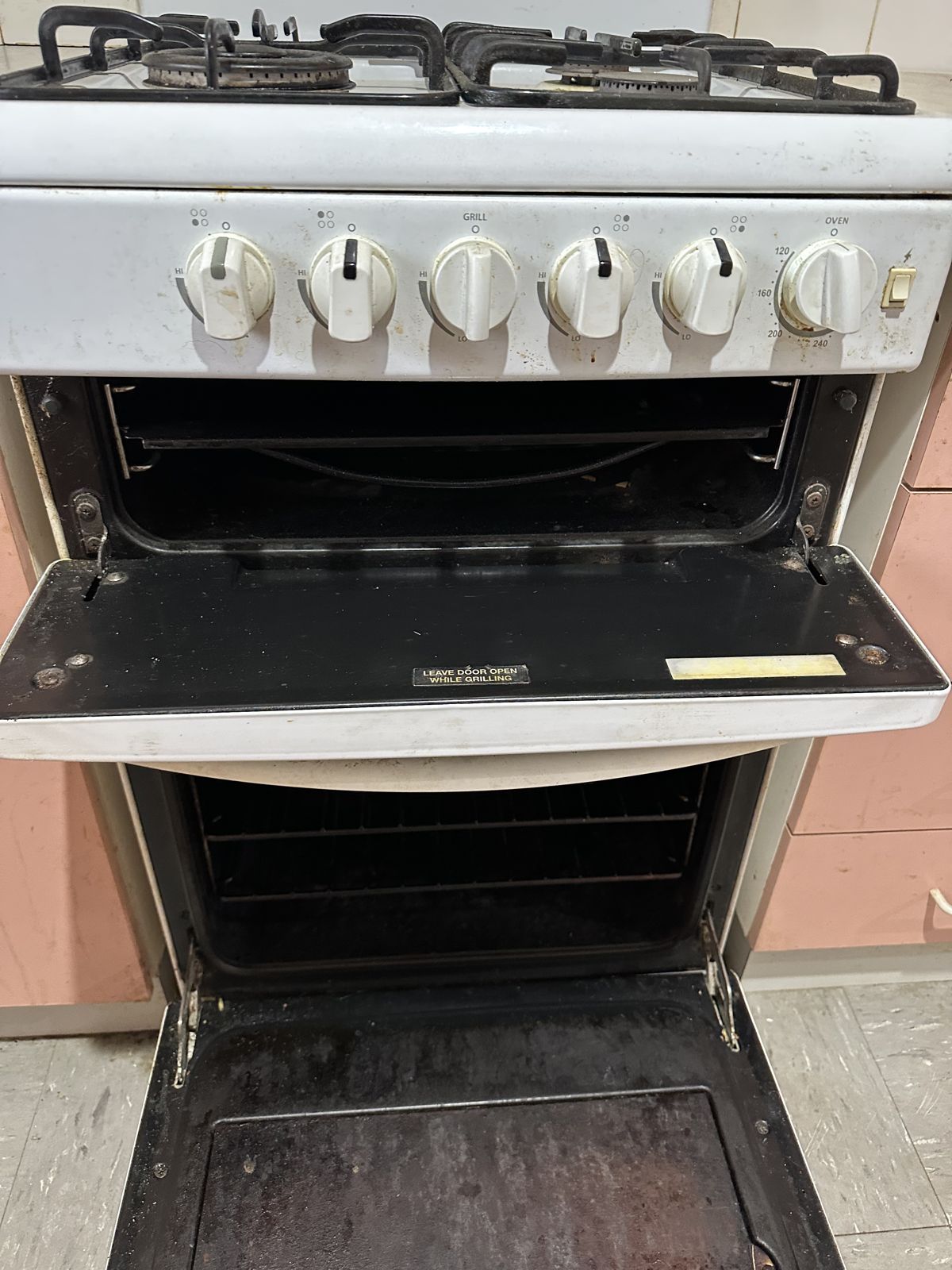 Oven with baked-on grease on the door and base before a deep clean