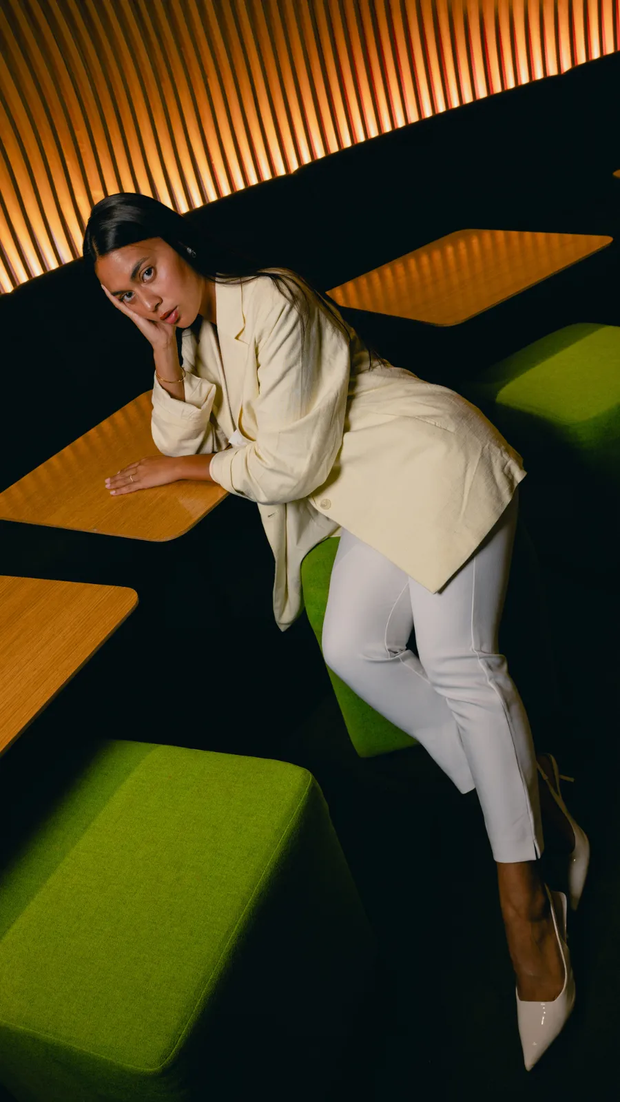 Femme en tailleur crème accoudée à une table, bar lounge design à Paris 1er