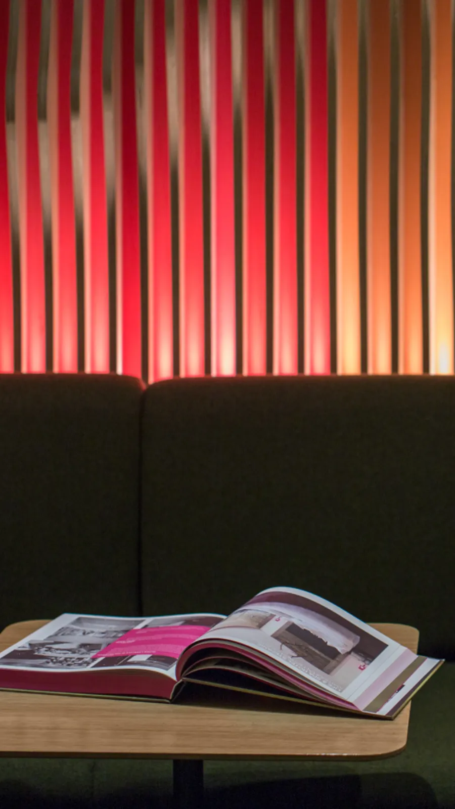 Magazine ouvert sous les lattes rouges éclairées, bar lounge design à Paris 1er