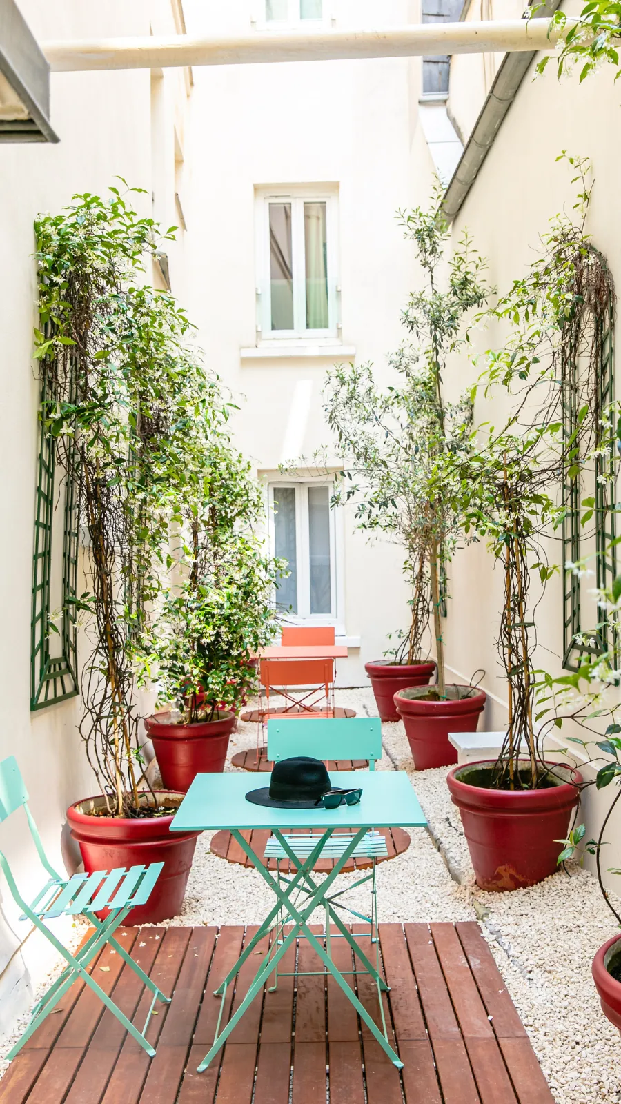 Tree-lined patio and turquoise bistro tables, ORA-ÏTO design hotel in Paris 1st arrondissement