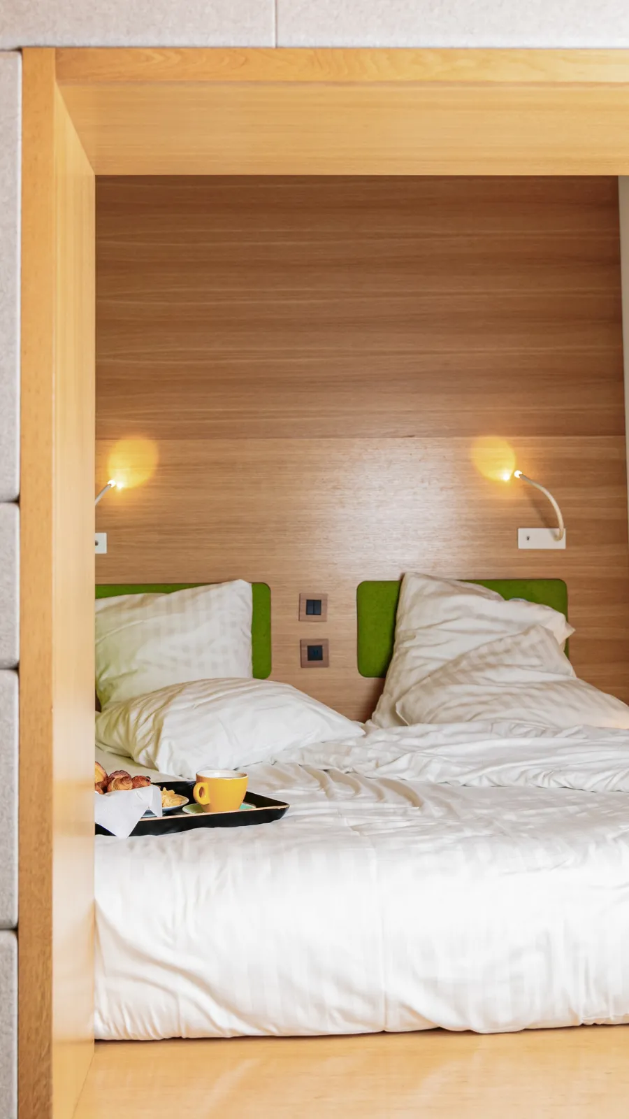 Wooden capsule and bed with anise green headboards, ORA-ÏTO design hotel in Paris 1st arrondissement