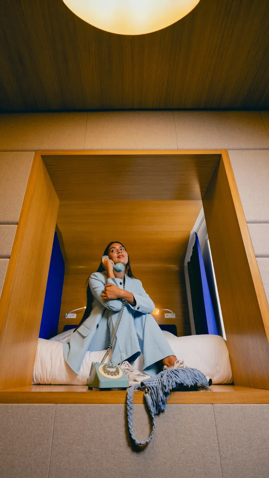 Woman on the phone in the bed alcove, ORA-ÏTO design hotel in Paris 1st arrondissement