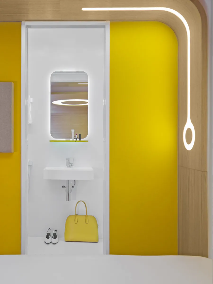 Yellow Cocoon room and white bathroom, capsule hotel in Paris 1st