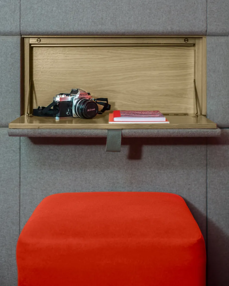 Secrétaire mural en bois et pouf rouge, hôtel capsule à Paris 1er