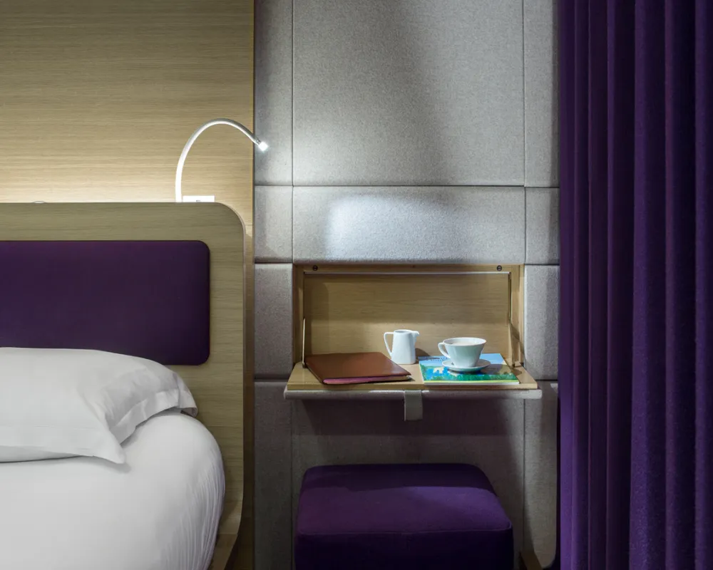 Chevet escamotable et tabouret violet, chambre Odyssey, hôtel capsule Paris 1er