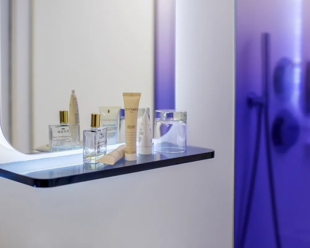 Produits d'accueil devant la douche violette, hôtel capsule à Paris 1er