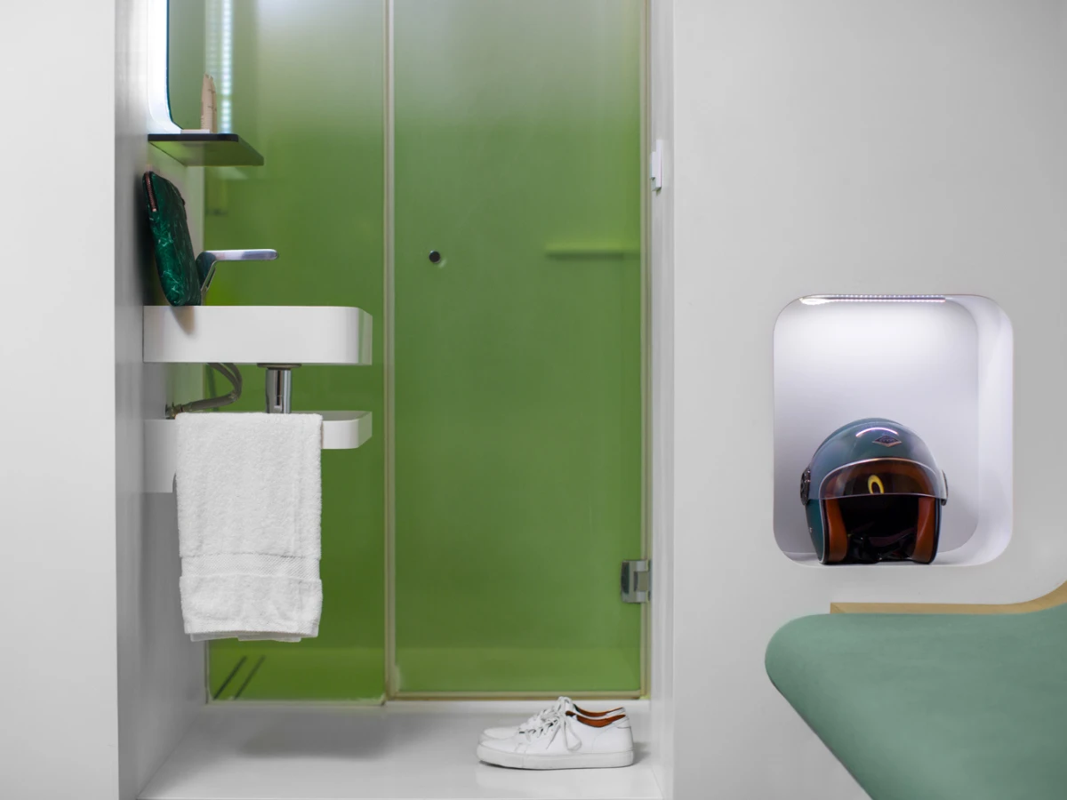 Douche vitrée verte et niche éclairée d'une chambre, hôtel design à Paris 1er