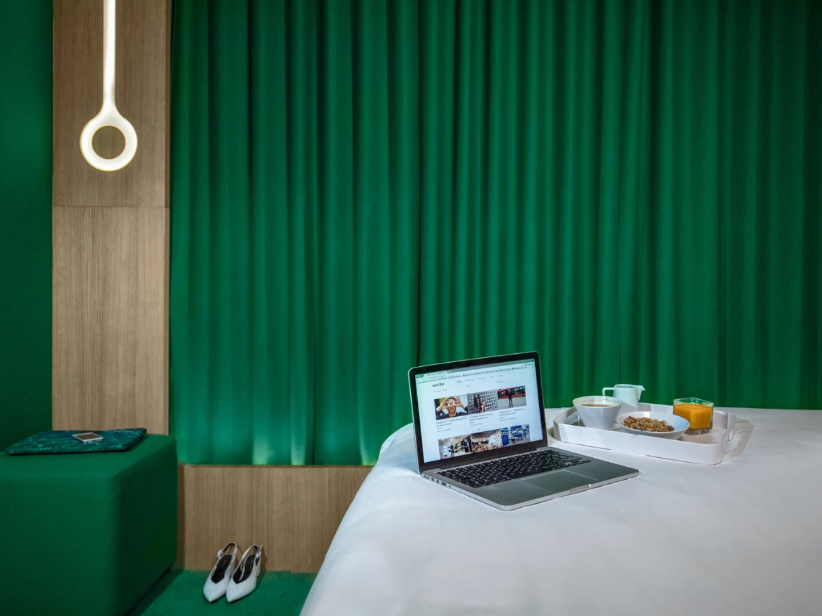Chambre verte, ordinateur et plateau sur le lit, hôtel design à Paris 1er