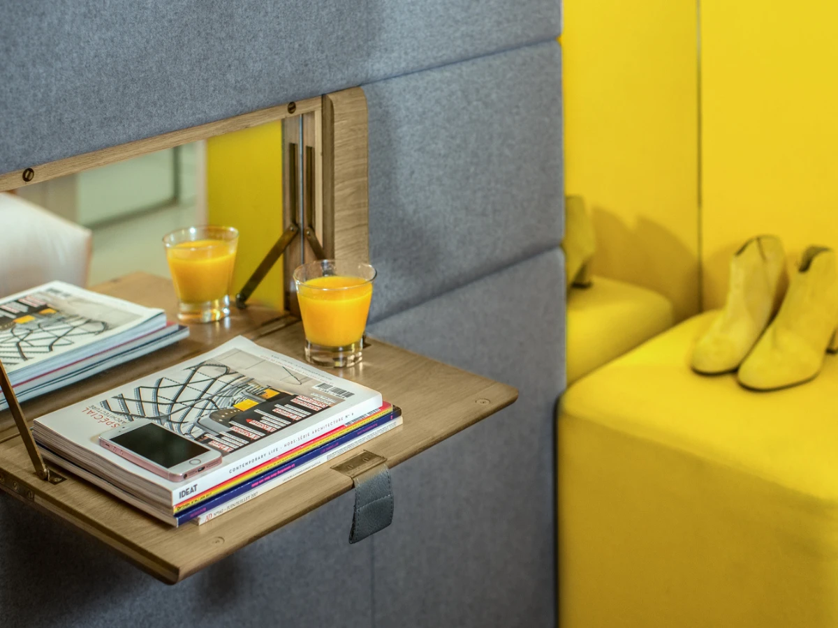 Tablette avec jus d'orange et pouf jaune, chambre de l'hôtel design à Paris 1er