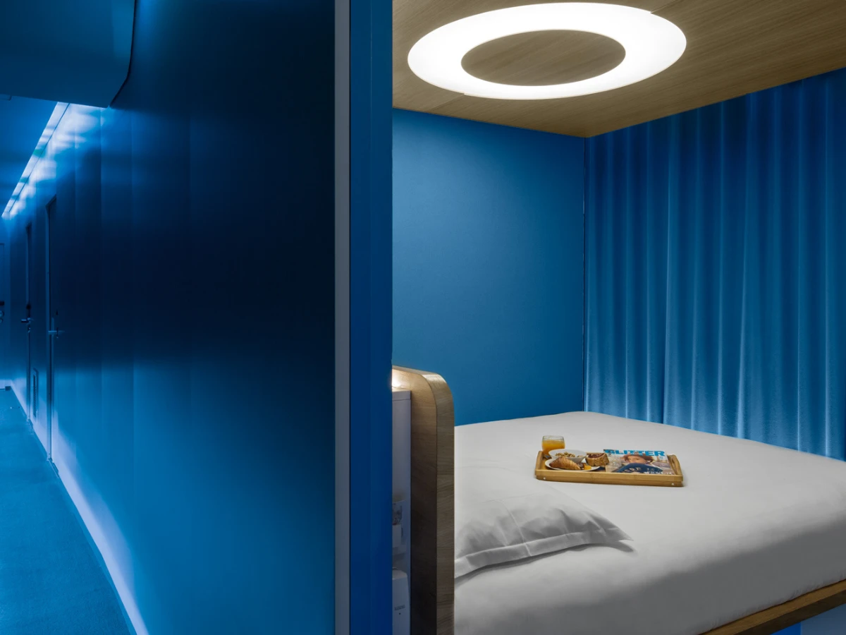 Chambre capsule bleue et plafonnier en anneau, hôtel design à Paris 1er