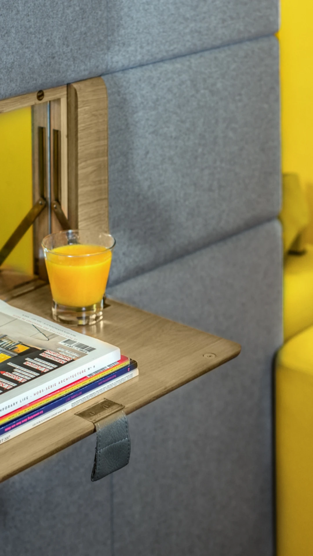 Wall-mounted shelf and yellow ottoman in a bedroom, boutique design hotel in Paris 1st arrondissement