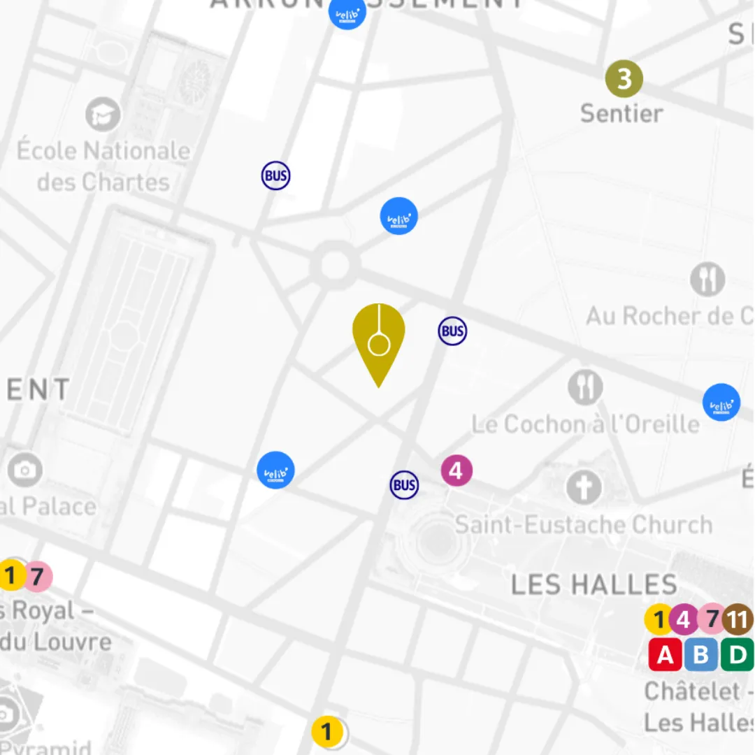 Carte partielle du quartier Les Halles à Paris avec des icônes bleues indiquant les stations Velib', des icônes circulaires jaunes et roses correspondant à des numéros de métro, et des icônes ovales bleues avec la mention 'BUS' représentant des arrêts de bus. Un grand marqueur jaune indique un point d'intérêt central proche des rues et places principales comme la place Royal et l'église Saint-Eustache.