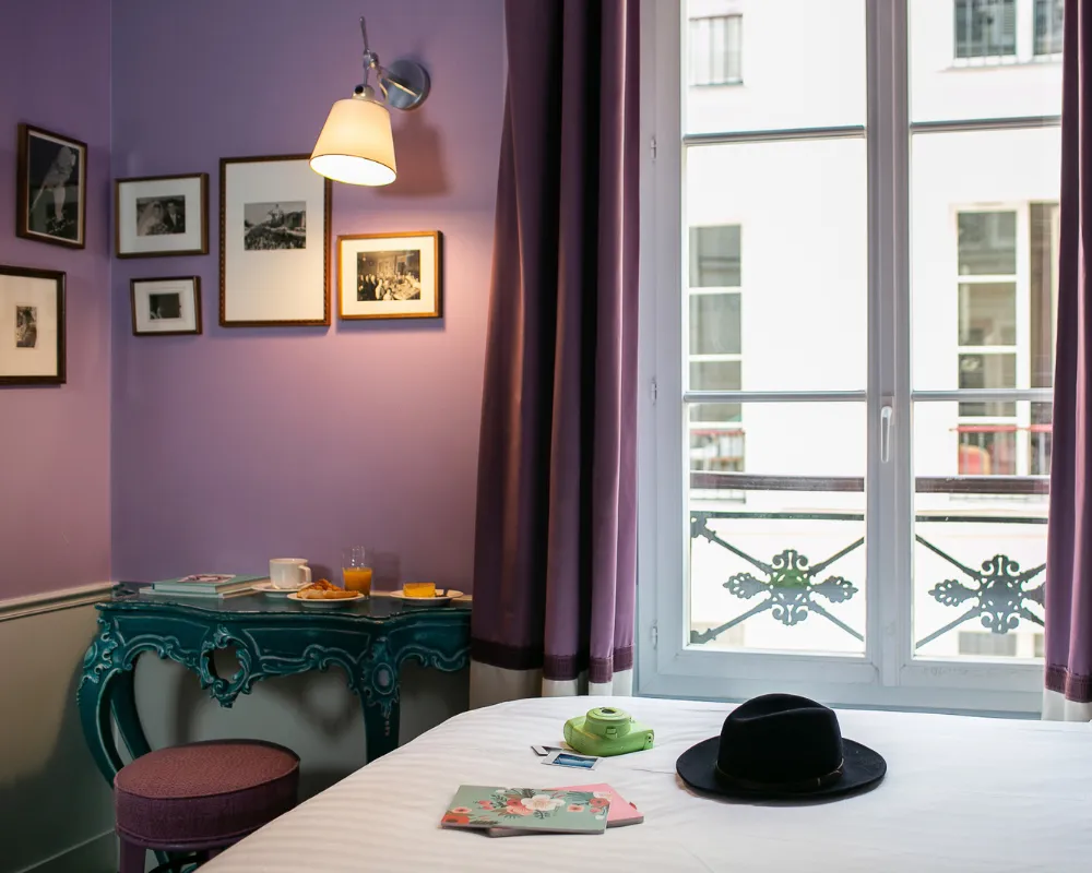 Chambre Singulière violette de l'Hôtel Crayon à Paris 1er : console baroque turquoise et fenêtre sur rue