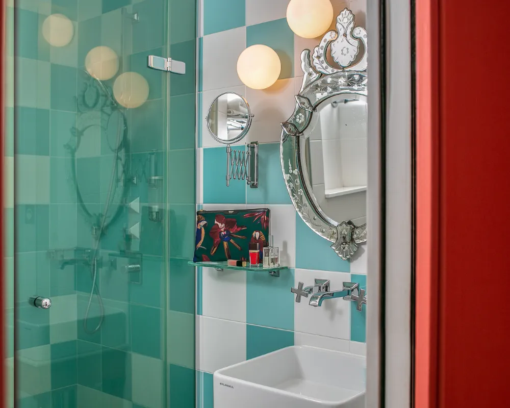 Douche carrelée vert menthe et miroir vénitien dans la salle d'eau d'une chambre de l'Hôtel Crayon à Paris