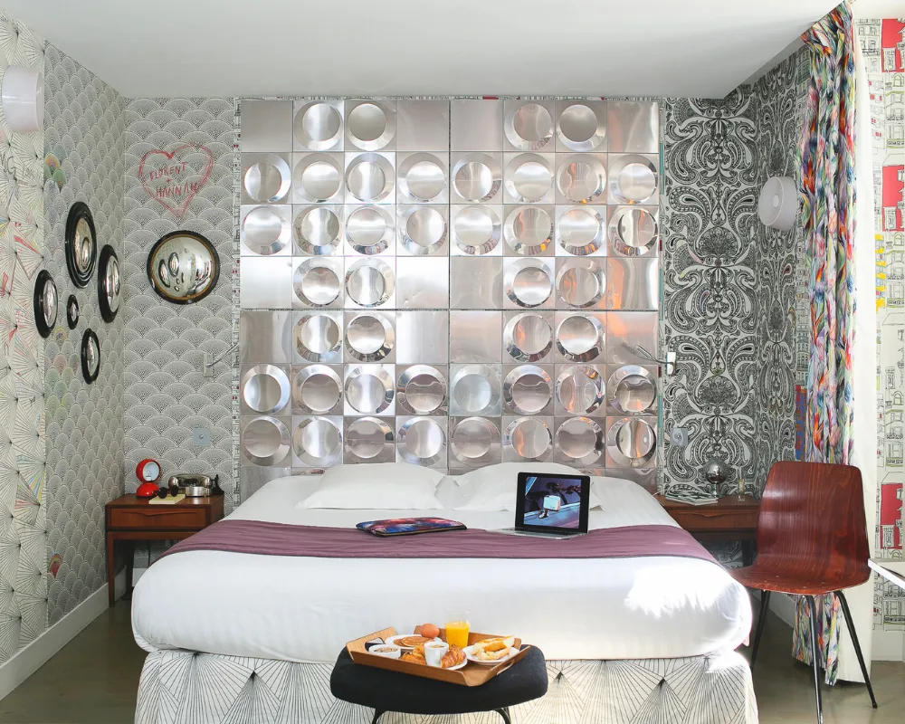 Lit double de la Suite Junior de l'Hôtel Crayon à Paris 1er, tête de lit en miroirs argentés et plateau petit-déjeuner