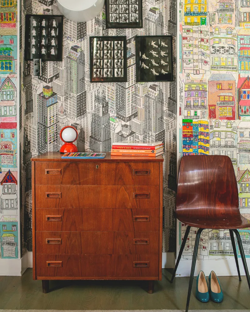 Commode vintage et papier peint illustré dans une chambre de l'Hôtel Crayon, boutique-hôtel à Paris 1er