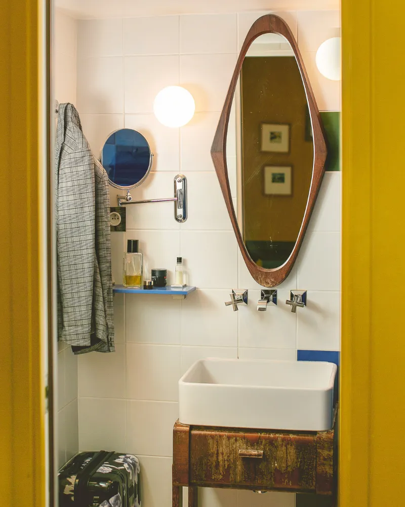 Salle d'eau avec vasque sur meuble vintage et miroir ovale en bois à l'Hôtel Crayon, Paris 1er