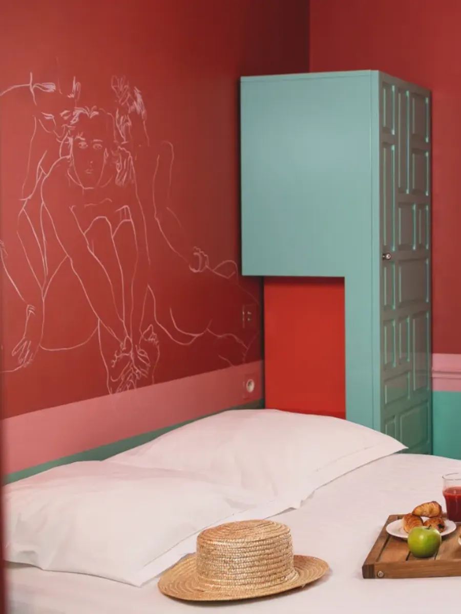 Singular Room for 1 person at Hôtel Crayon, Paris 1st: red illustrated wall, turquoise wardrobe, and breakfast