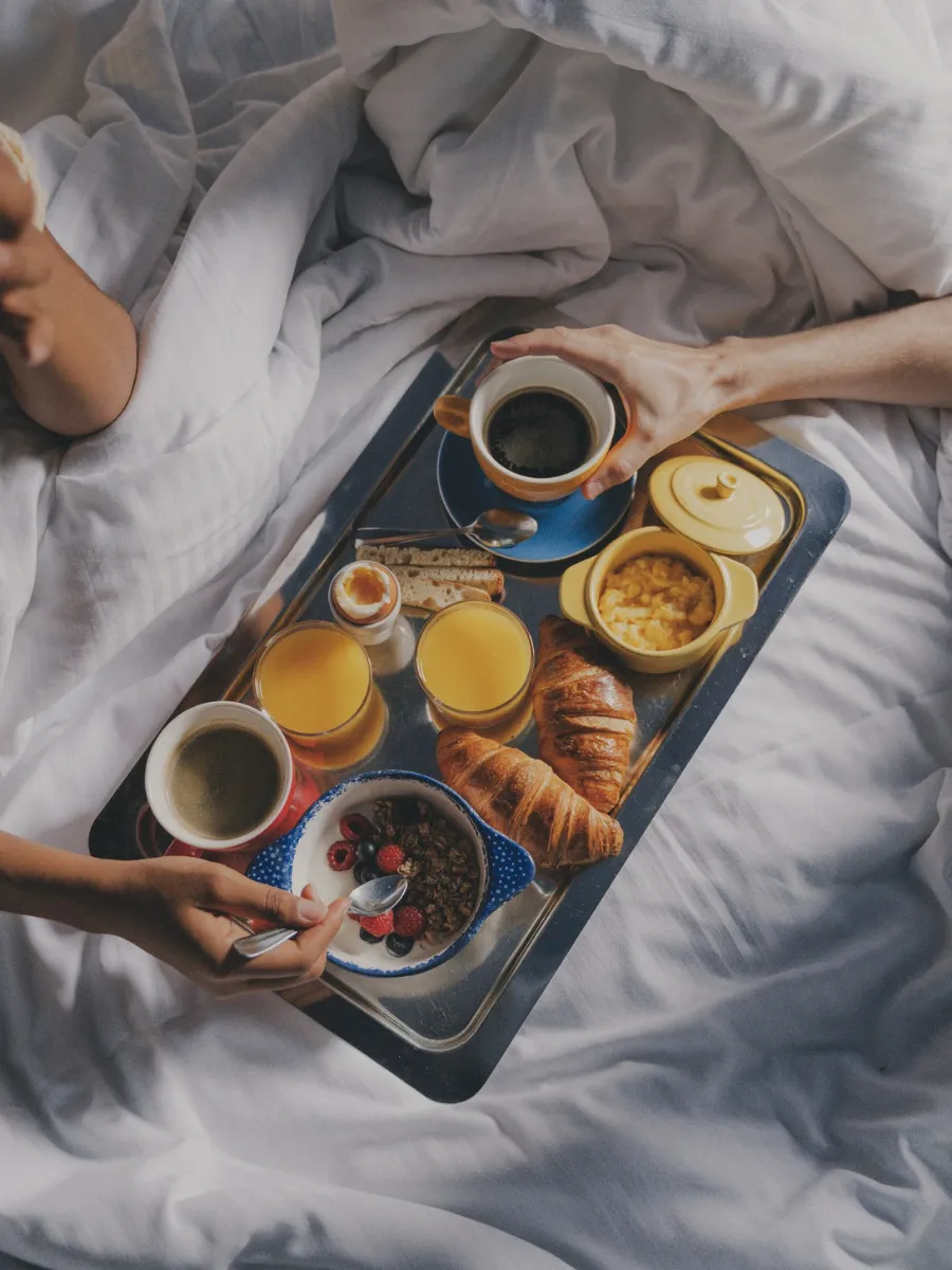 Breakfast in bed tray with croissants, orange juice, and coffee at Hôtel Crayon, Paris 1st arrondissement