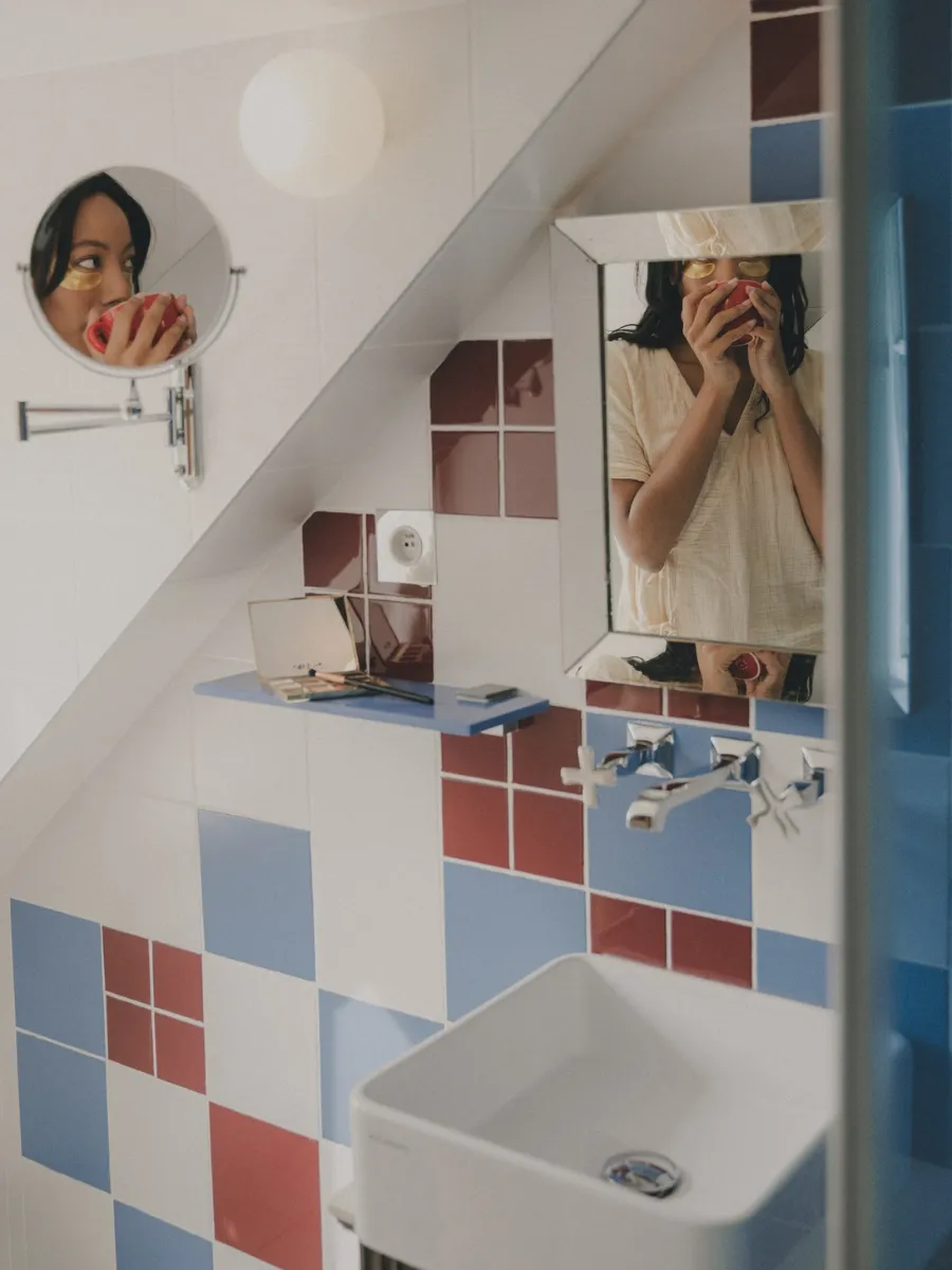Attic bathroom with blue and red tiling and a white basin at Hôtel Crayon, Paris 1st arrondissement