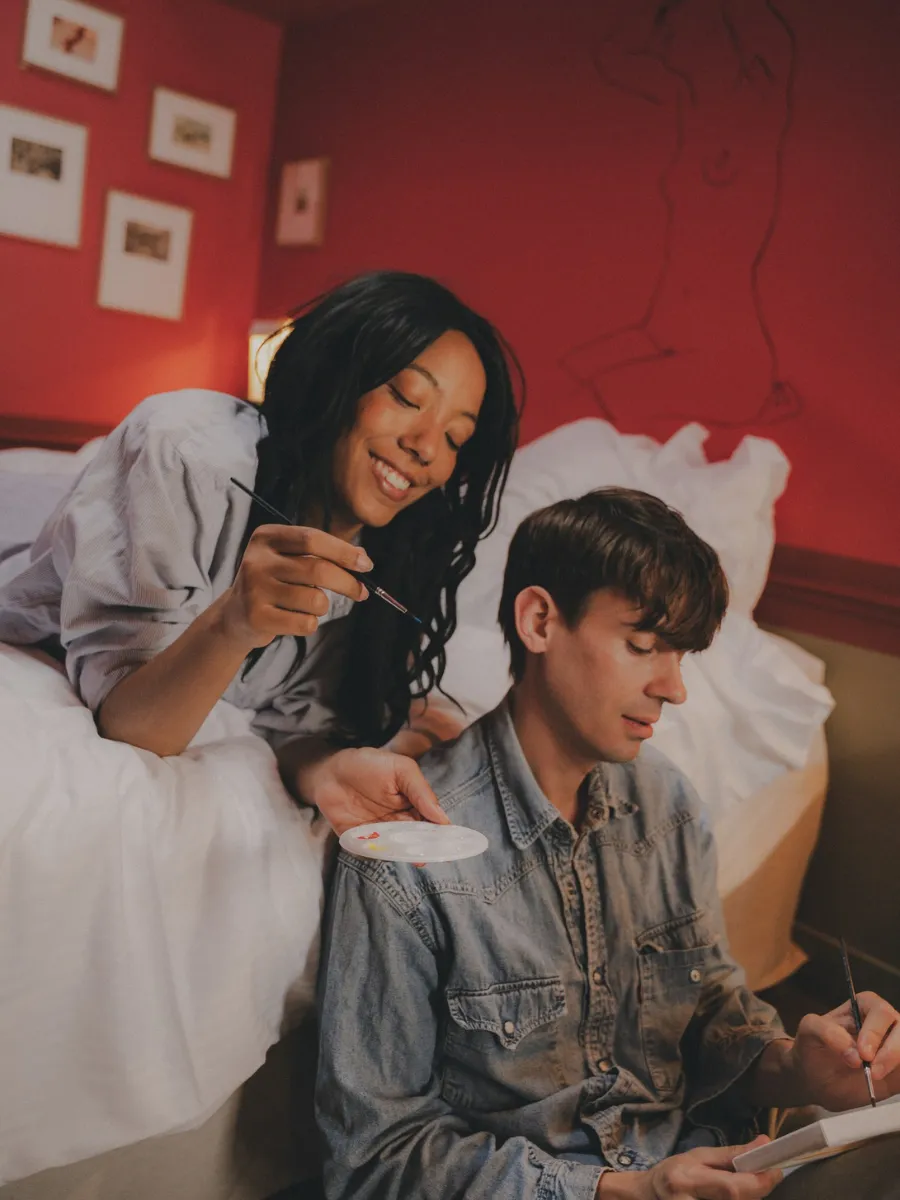 Couple sharing breakfast in a red room at Hôtel Crayon, a boutique hotel in Paris's 1st arrondissement