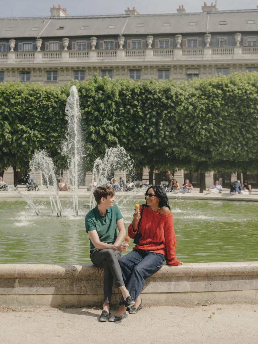 Couple sitting by the fountain in the Palais-Royal garden, 5 minutes from Hôtel Crayon, Paris 1st arrondissement