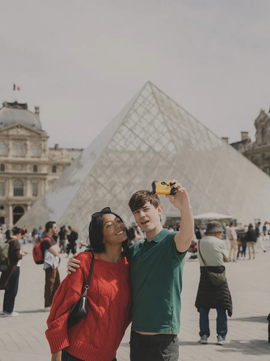 Selfie devant la pyramide du Louvre, monument emblématique à 8 minutes à pied de l'Hôtel Crayon, Paris 1er